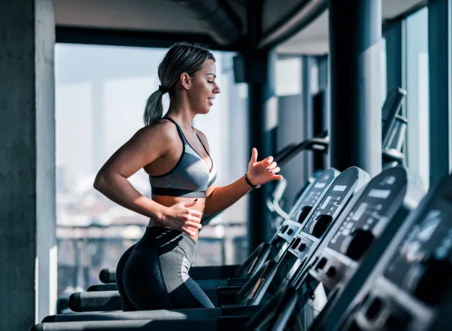 woman doing treadmill sprints at gym, concept of belly fat exercises